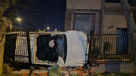 Condutor ficou preso nas ferragens após o impacto e foi resgatado pelos bombeiros; moradores escaparam sem ferimentos graves